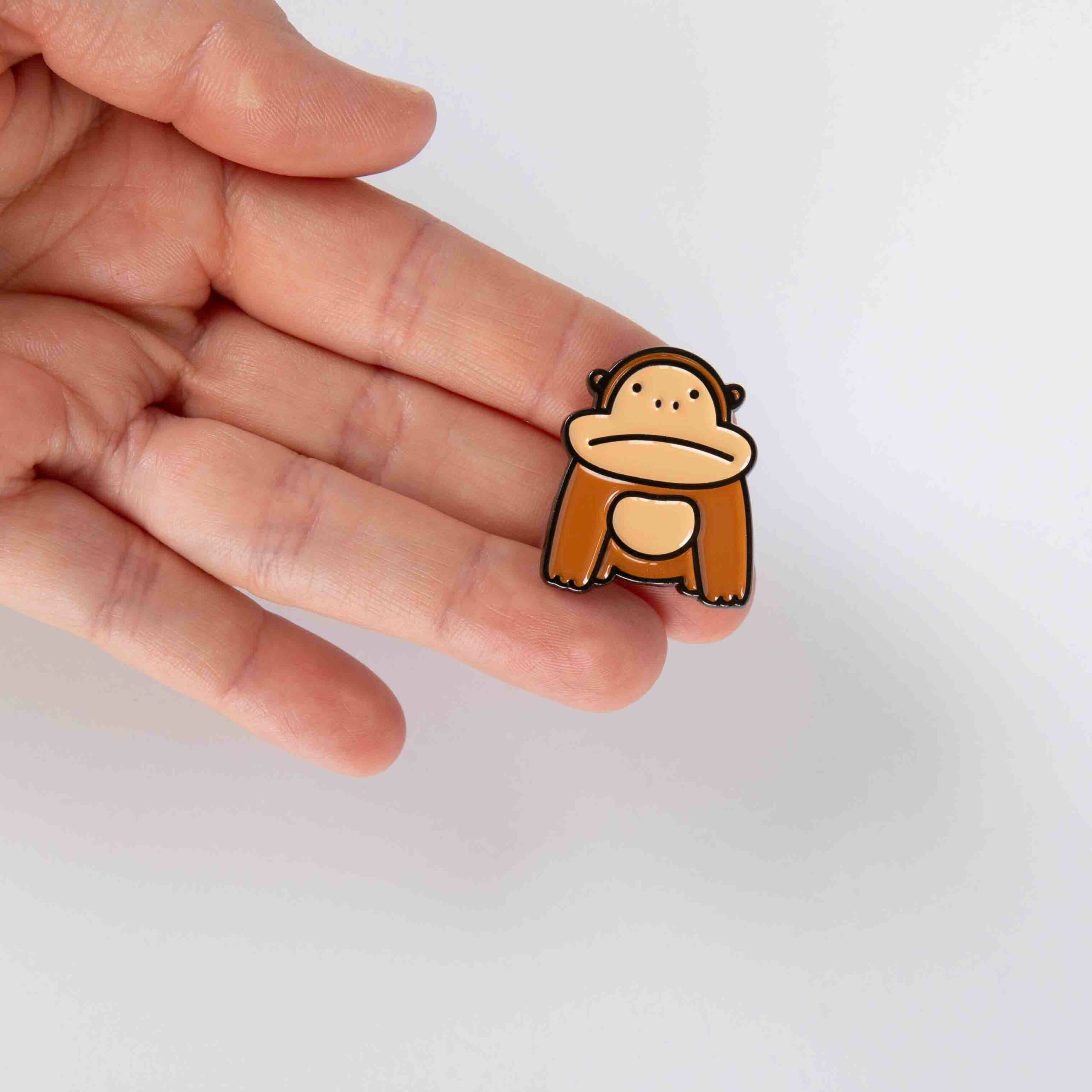 Gorilla enamel pin in hand to show scale